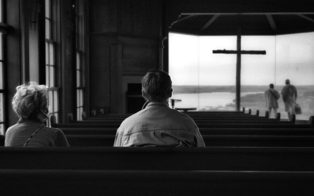 Photo of a couple sitting in a pew by Nolan Kent on Unsplash